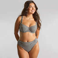woman wearing a black and white bikini against a grey background