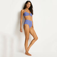 woman wearing a blue and white checkered bikini on a plain background