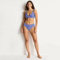 woman wearing a blue and white checkered bikini on a light background