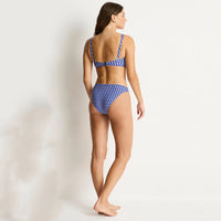 woman wearing a blue and white checkered bikini on a plain background