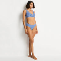woman wearing a blue and white checkered bikini against a white background