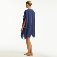 woman wearing a blue poncho on a white background