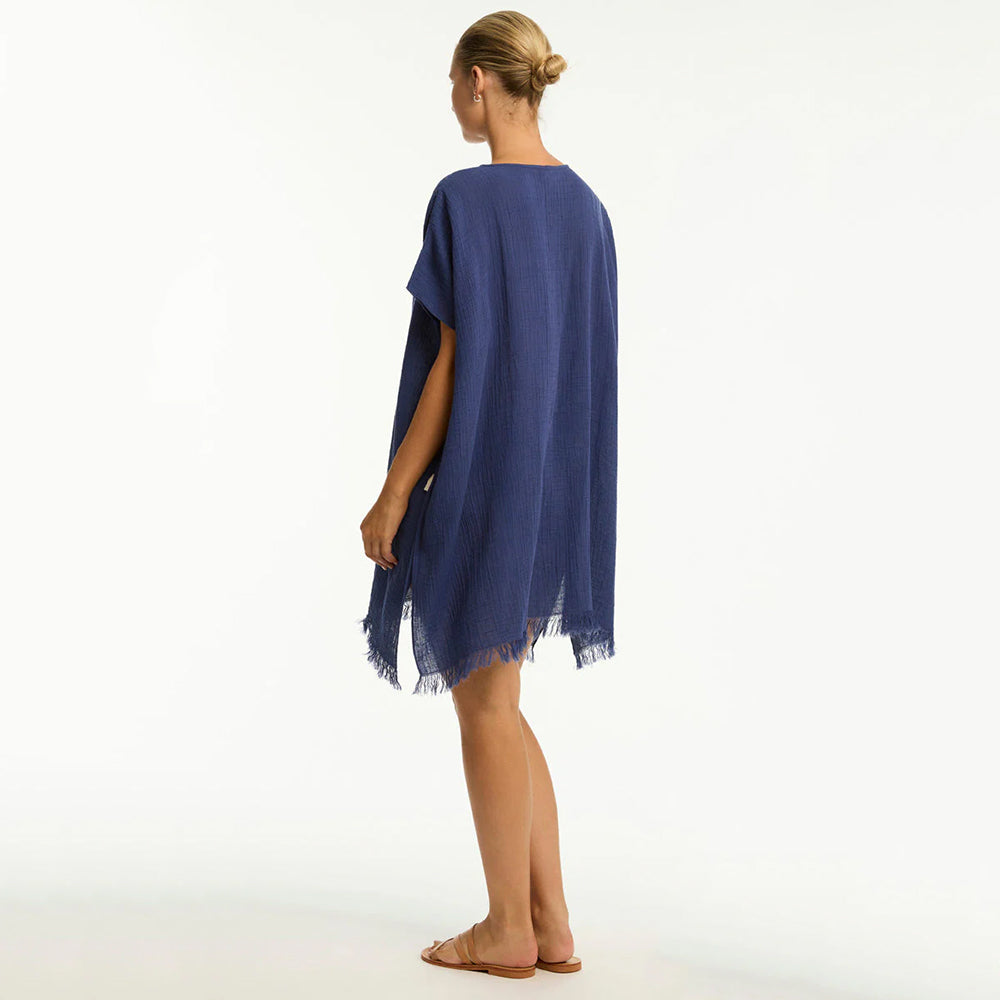 woman wearing a blue poncho on a white background
