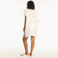 woman wearing a white dress with frayed hem on a white background