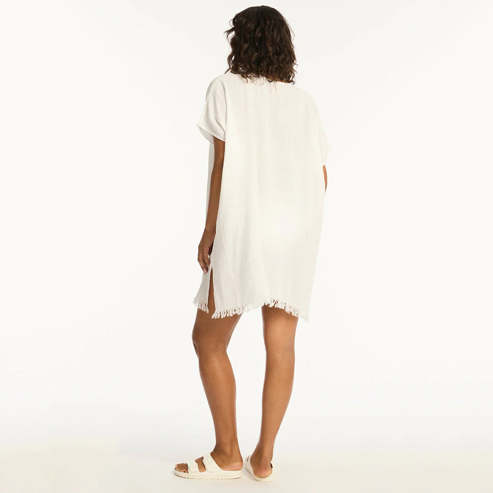 woman wearing a white dress with frayed hem on a white background