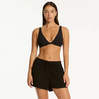 sea level bikini top and  black sunset beach shorts on model