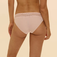 light pink lace-trimmed underwear on a beige background