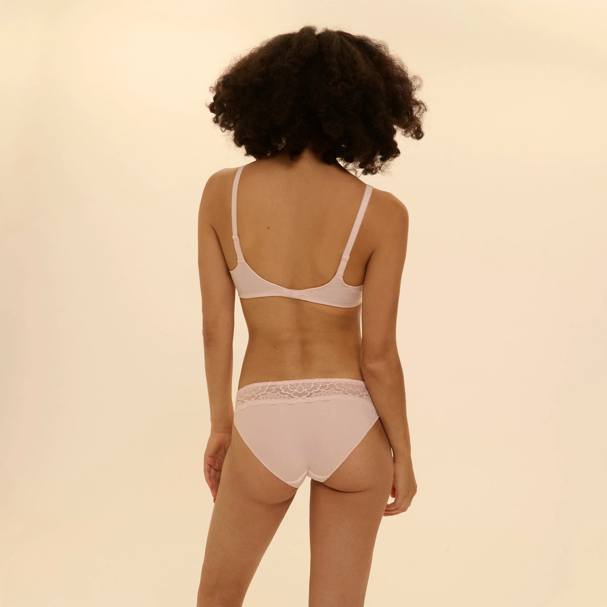person wearing caresse bra and panties set on a beige background