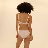person wearing caresse bra and panties set on a beige background