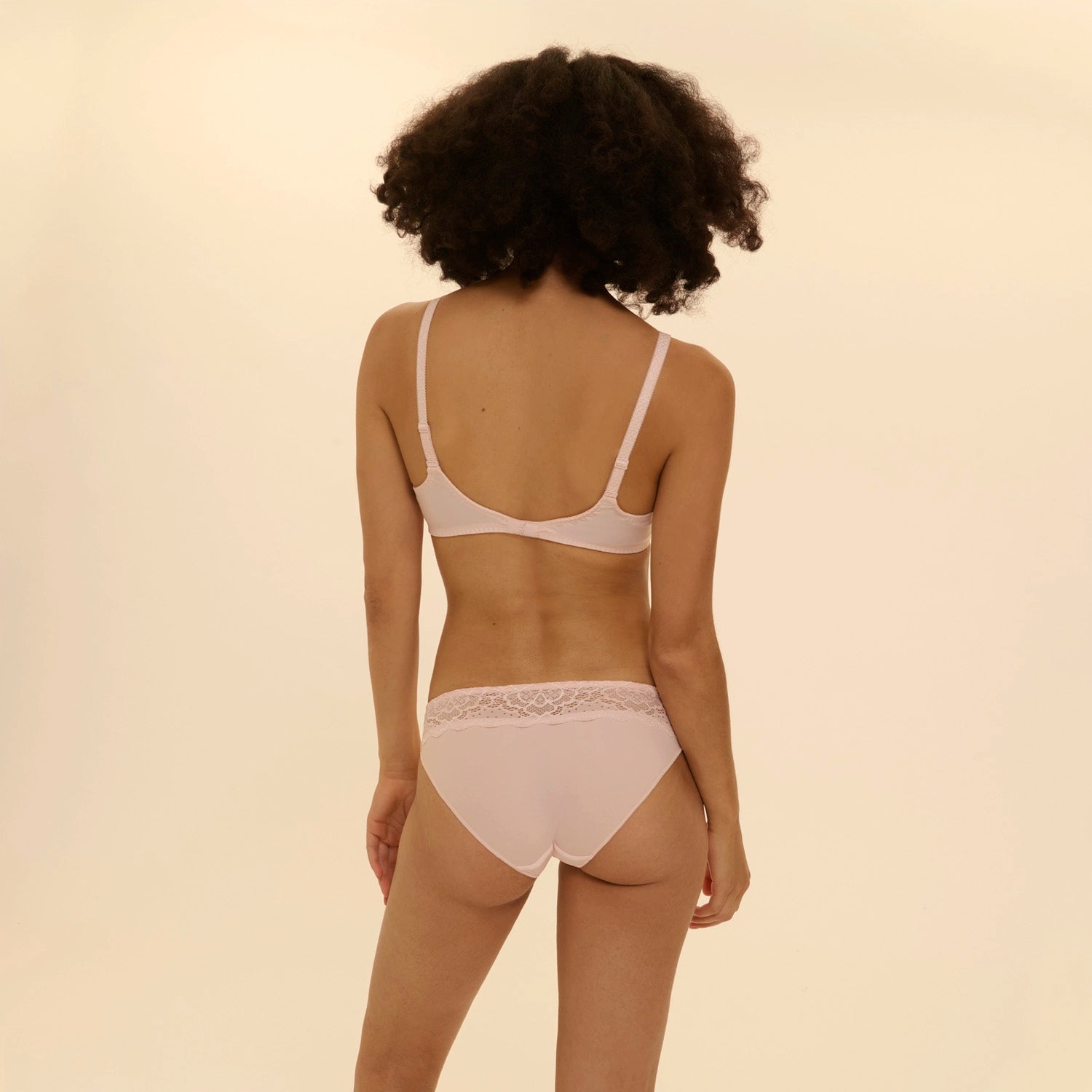 person wearing caresse bra and panties set on a beige background