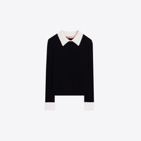 A black long-sleeve knit top with a contrasting ecru pointed collar and white turned-back cuffs, displayed flat against a light gray background.