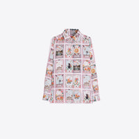 A long-sleeve button-up shirt with a white base and a pink border, featuring a repeating grid pattern of colorful vintage card illustrations, shown against a plain light gray background.