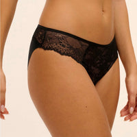 Black lace panties with a sheer floral lace panel and solid black waistband, shown on a model against a light beige background.