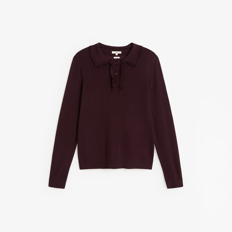 A dark plum long-sleeve knit top with a ruffled collar and a small ruffle detail at the placket, shown flat on a light gray background.