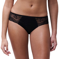 Black lace panties worn by a model, shown from the waist to upper thighs against a plain white background.