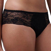 Black lace panties shown on a model, featuring a sheer floral lace panel and solid black fabric on the front, photographed against a plain white background.
