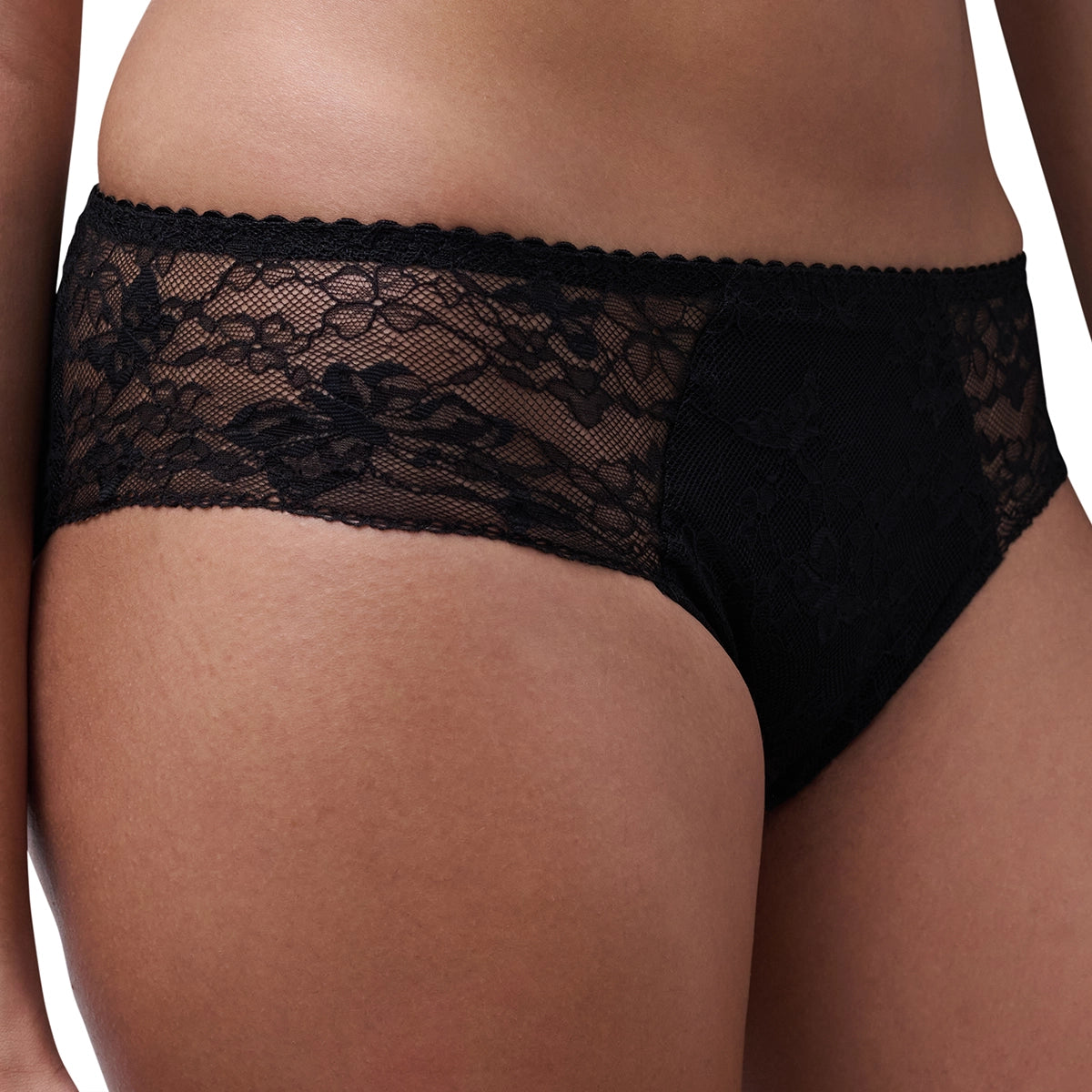 Black lace panties shown on a model, featuring a sheer floral lace panel and solid black fabric on the front, photographed against a plain white background.