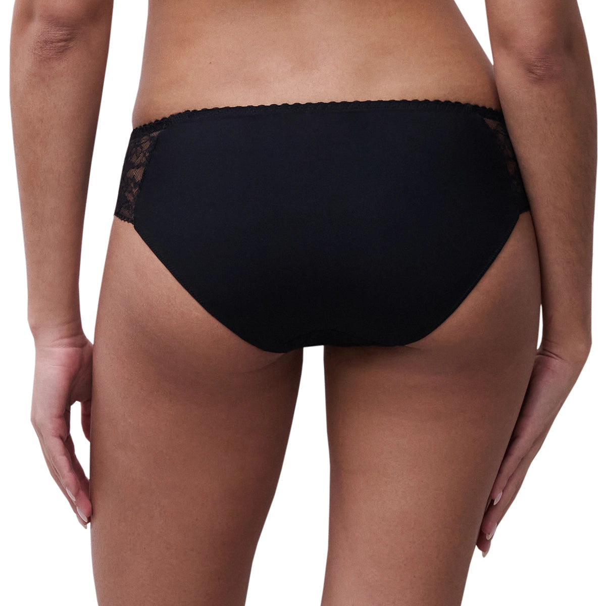 Rear view of a model wearing black lace-trimmed underwear against a plain white background.