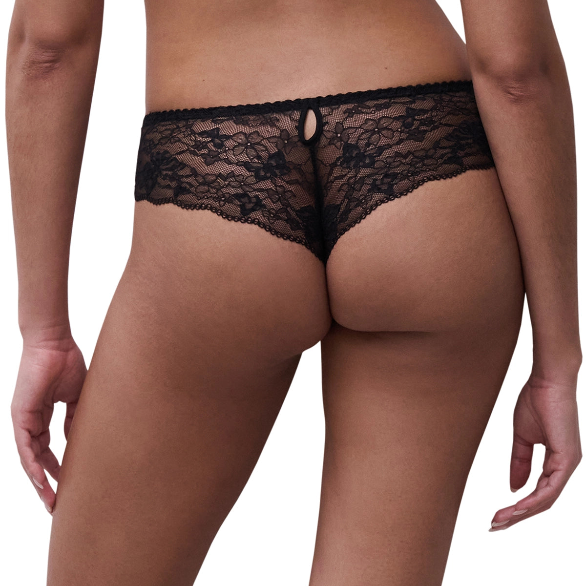 Rear view of a model wearing black lace panties against a plain white background.