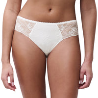 A close-up of a model wearing white lace panties against a plain white background.