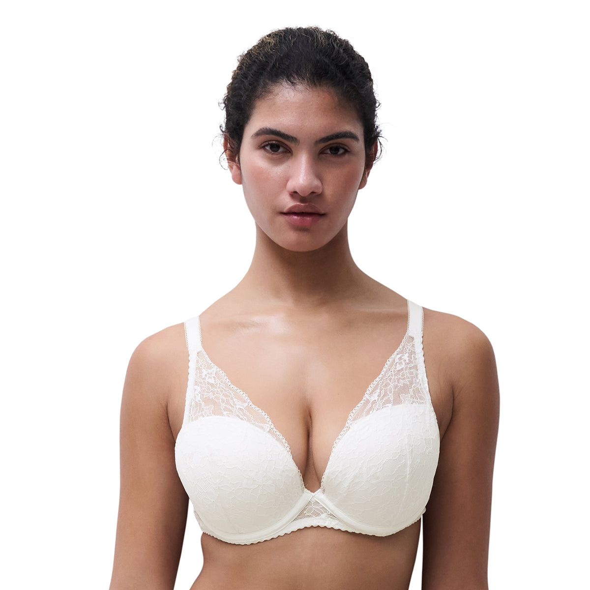 A woman modeling a white lace-trimmed underwire bra against a plain white background.