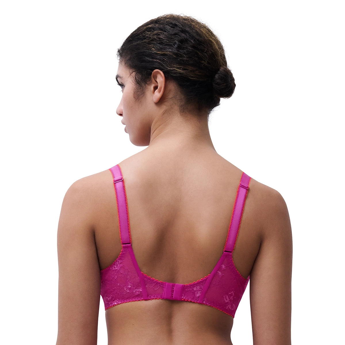 A woman shown from the back wearing a bright pink lace underwire bra against a plain white background.