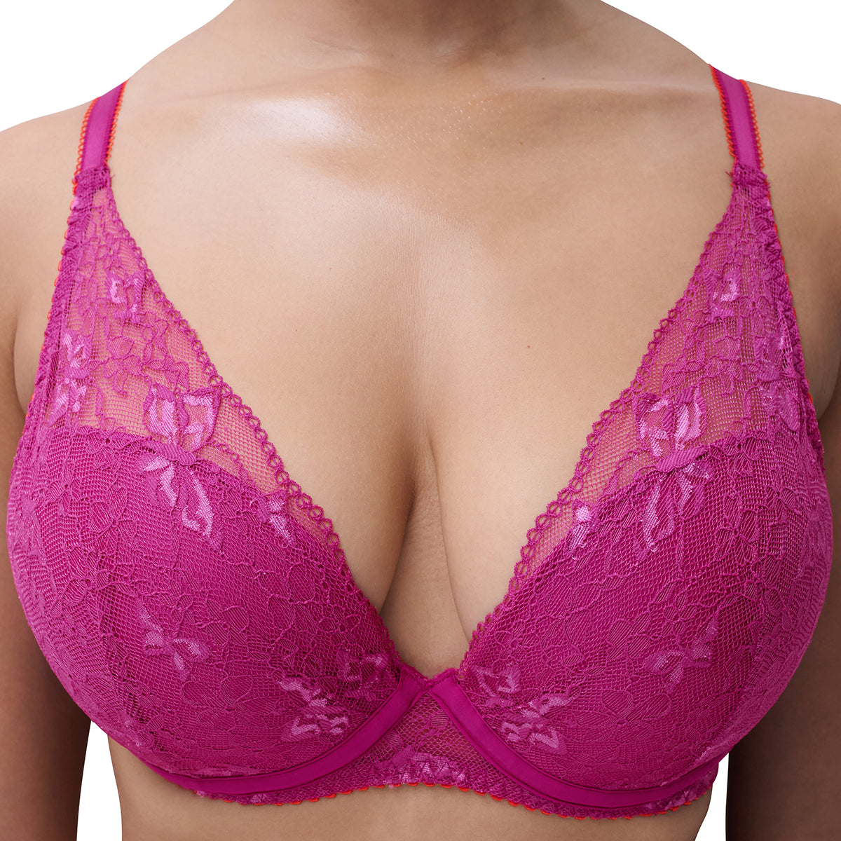 A close-up of a model wearing a bright magenta lace bra, showing the intricate floral lace pattern and underwire details.