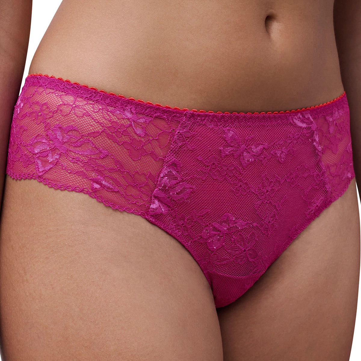 A close-up of a model wearing bright magenta lace panties with a sheer mesh panel and floral lace pattern.