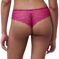 Rear view of a model wearing bright pink lace thong panties against a plain white background.