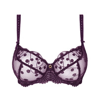 A dark purple sheer lace bra with a polka dot pattern, scalloped edges, and a small gold button at the center, shown against a plain white background.