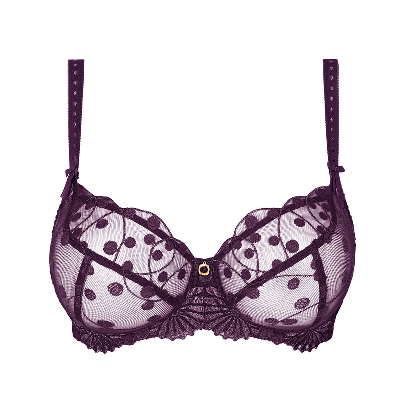 A dark purple sheer lace bra with a polka dot pattern, scalloped edges, and a small gold button at the center, shown against a plain white background.