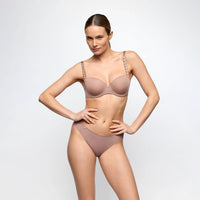 A model wearing a matching two-piece lingerie set in a dusty rose color, featuring a bra with embellished straps and high-waisted briefs, set against a plain light gray background.