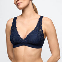 Navy blue lace bra on a model against a plain background