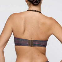 Back view of a woman wearing a halter neck bra on a plain background