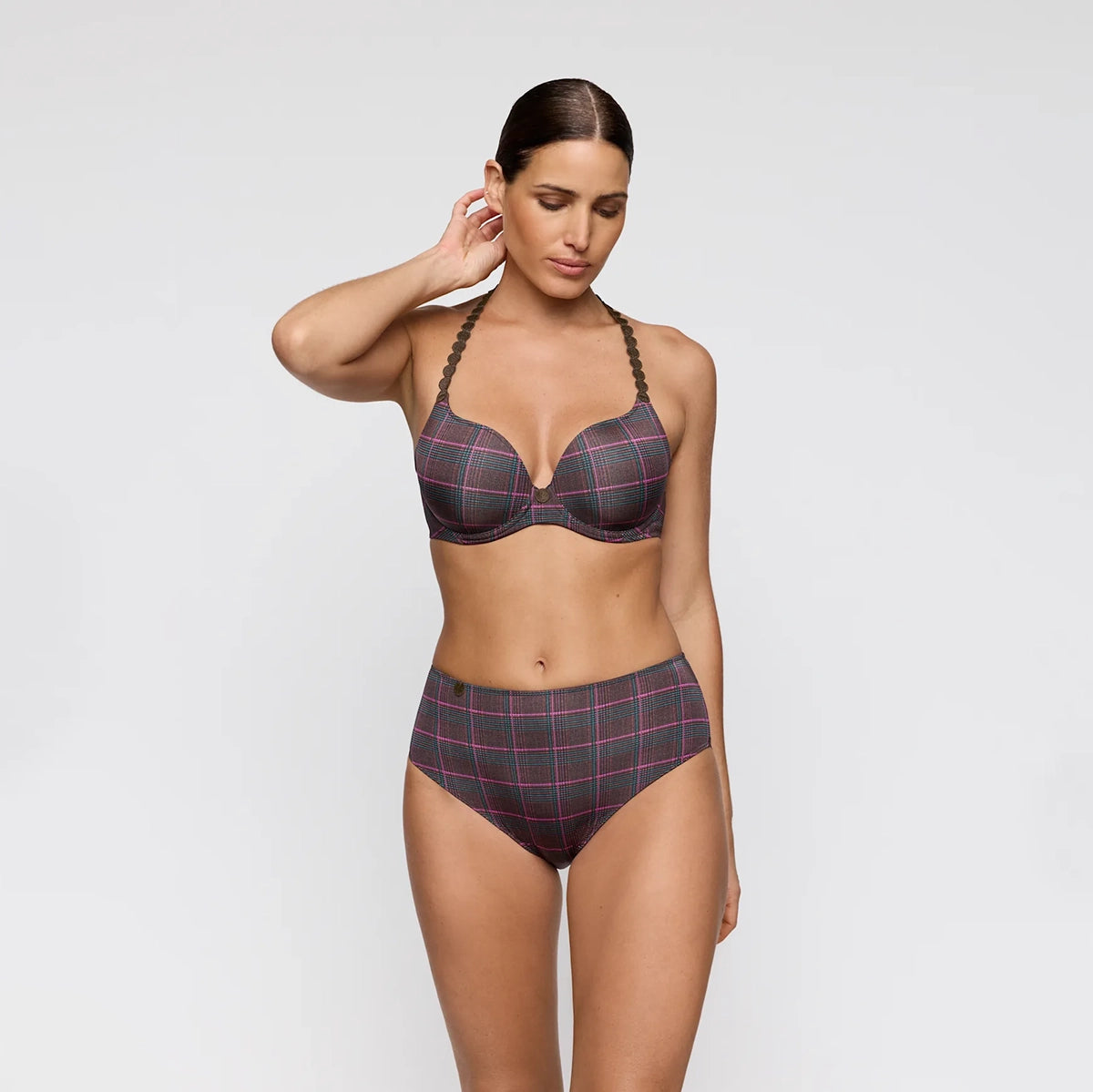 A woman modeling a two-piece bikini set featuring a dark gray and red plaid pattern with braided shoulder straps, set against a plain light gray background.