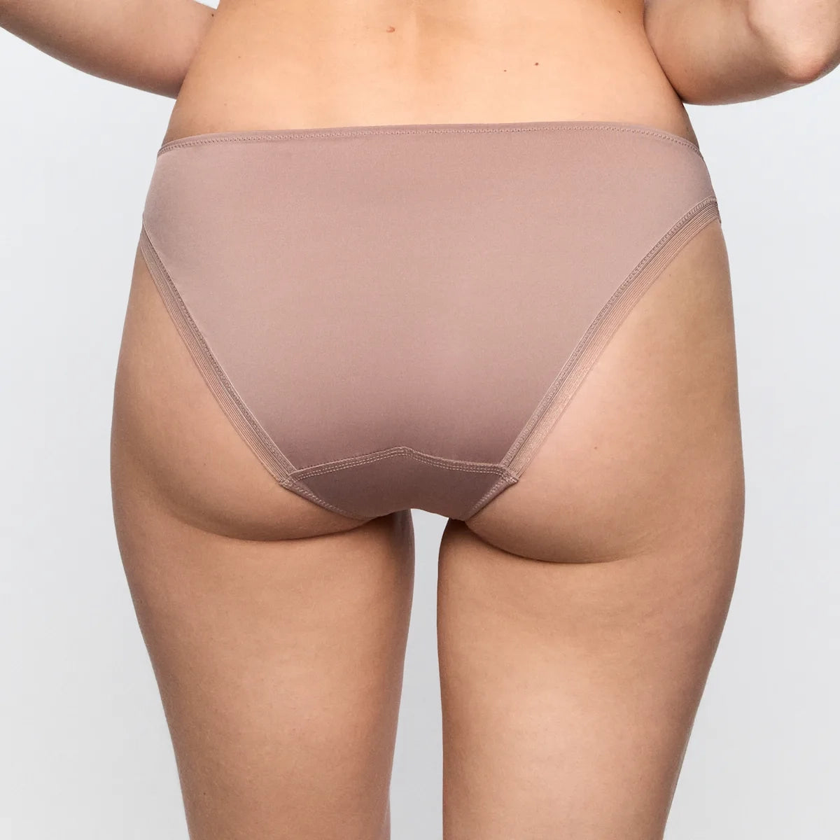 Beige underwear worn by a person on a plain background