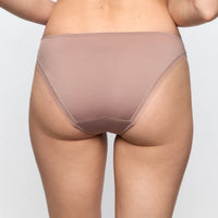 Beige underwear worn by a person on a plain background