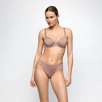 marie jo tom lingerie set in neutral colour worn by a model on a plain background