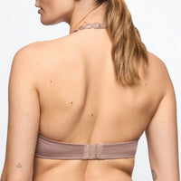 Rear view of a woman wearing a strapless bandeau-style bra in a muted mauve-taupe color, with a matching thin chain necklace visible against a plain light background.